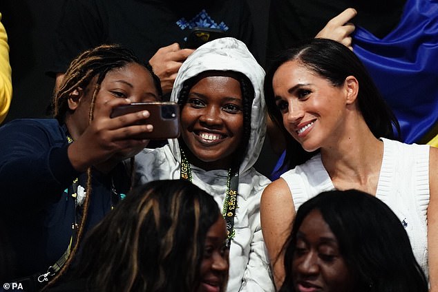 Joining in! The Duchess of Sussex (right) poses for a picture at the sitting volleyball competition