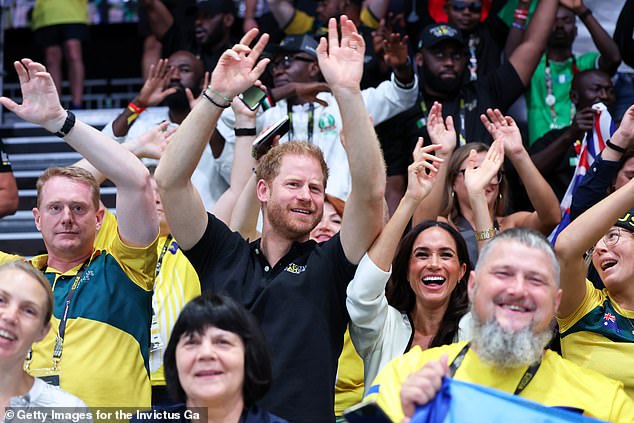 Prince Harry and Meghan Markle wave their hands at the wheelchair basketball match today