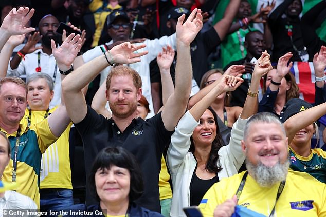 Prince Harry and Meghan Markle wave their hands at the wheelchair basketball match today