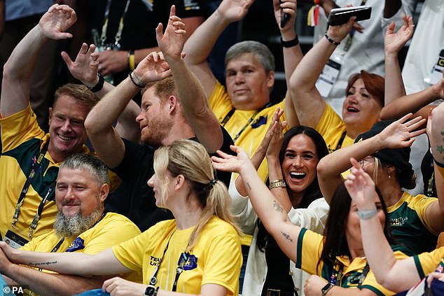 Prince Harry and Meghan Markle wave their hands at the wheelchair basketball match today