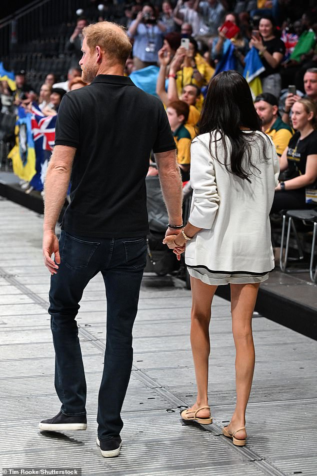 Prince Harry and Meghan Markle greet a member of the crowd in Dusseldorf this morning