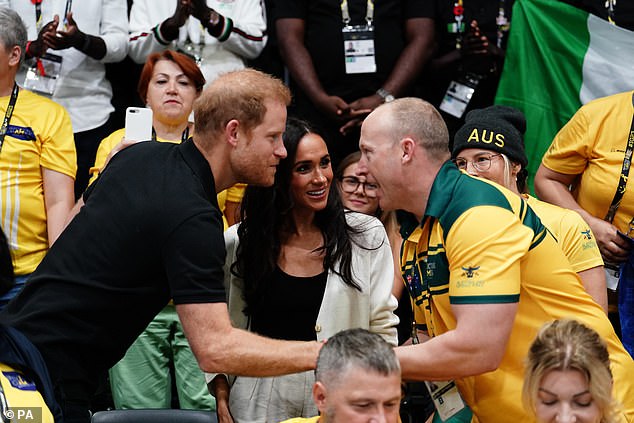 Prince Harry and Meghan Markle greet a member of the crowd in Dusseldorf this morning