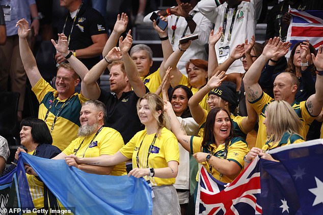 Prince Harry and Meghan Markle wave their hands at the wheelchair basketball match today