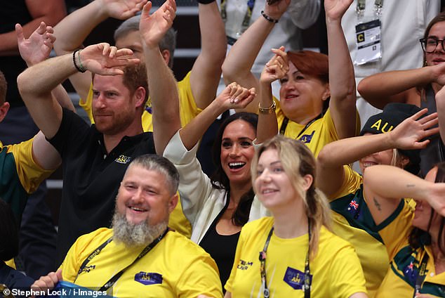 Prince Harry and Meghan Markle wave their hands at the wheelchair basketball match today