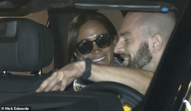 The Duchess of Sussex beams after arriving at Dusseldorf Airport this afternoon