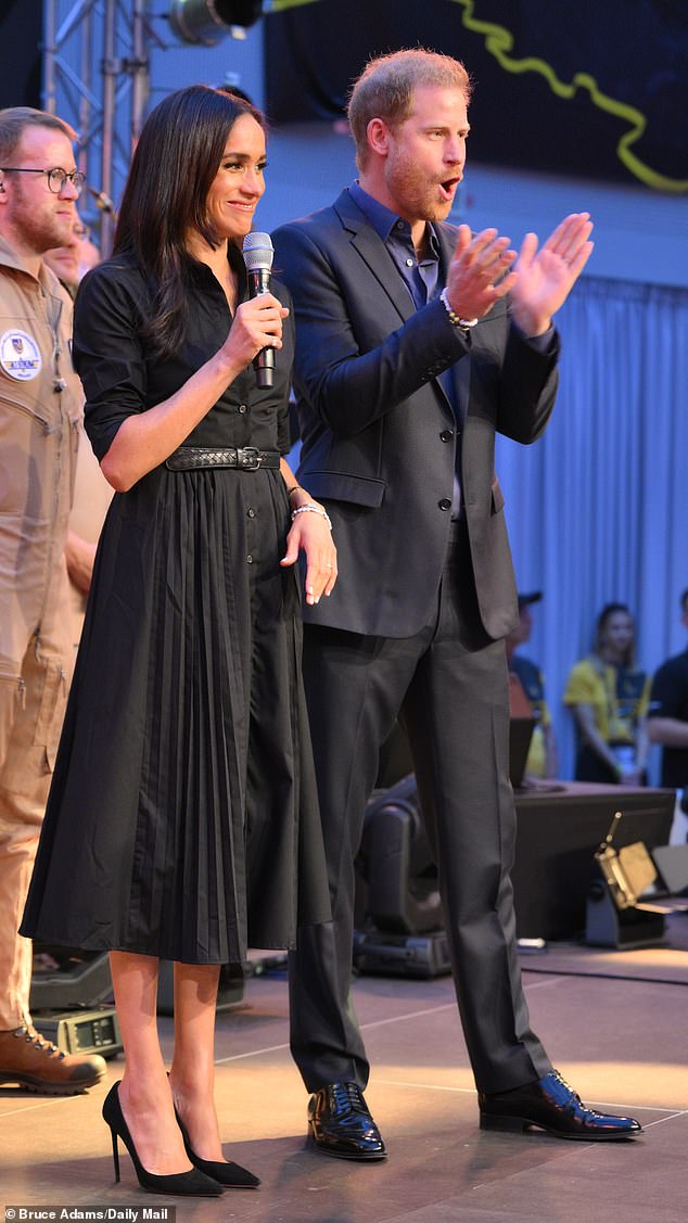 The Duchess of Sussex stunned in a black shirt dress with button detailing, a belt at the waist and a pleated skirt as she attended her first Invictus Games event in Dusseldorf this evening