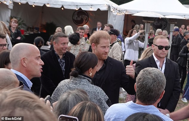 Harry gives another guest the thumbs up as he chats to attendees