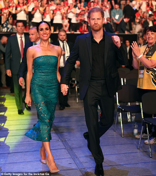 Upon arriving at the arena, Meghan put on a cheery display while Harry looked bold and determined, holding his fist in the air