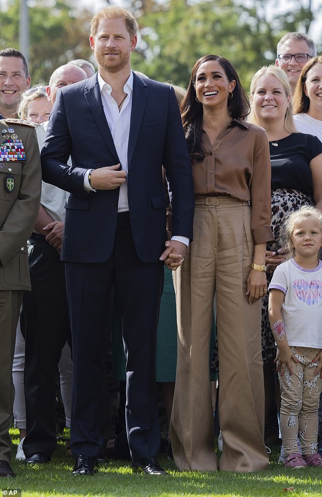 Meghan Markle opted for another muted outfit as she sported a brown silky shirt and trousers to join Prince Harry at the Invictus Games