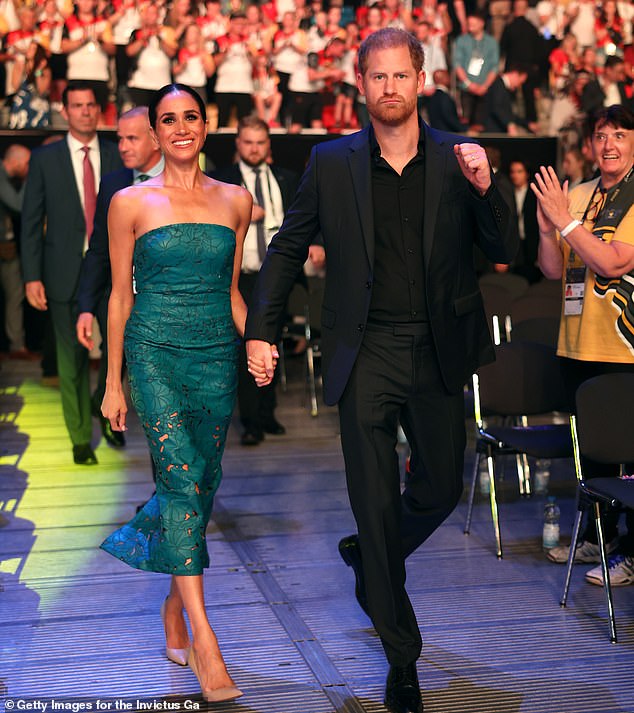 Upon arriving at the arena, Meghan put on a cheery display while Harry looked bold and determined, holding his fist in the air