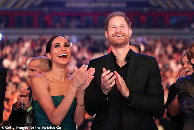 Meghan and Harry enjoying the closing ceremony at the Invictus Games in Dusseldorf as they were photographed with wide grins across their faces