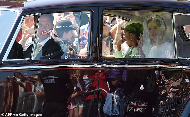 Pictured: Meghan and her mother, Doria Ragland, driven along the Long Walk in the maroon-coloured Rolls-Royce Phantom IV as they arrive for her wedding ceremony