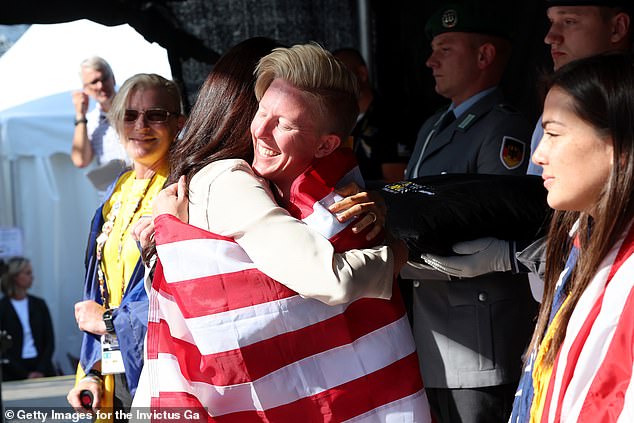 Wearing £260 trousers and a £580 trench coat from Cuyana as well as £545 Aquazurra purist pumps the royal hugged the athlete donning the star-spangled banner and couldn't help but grin