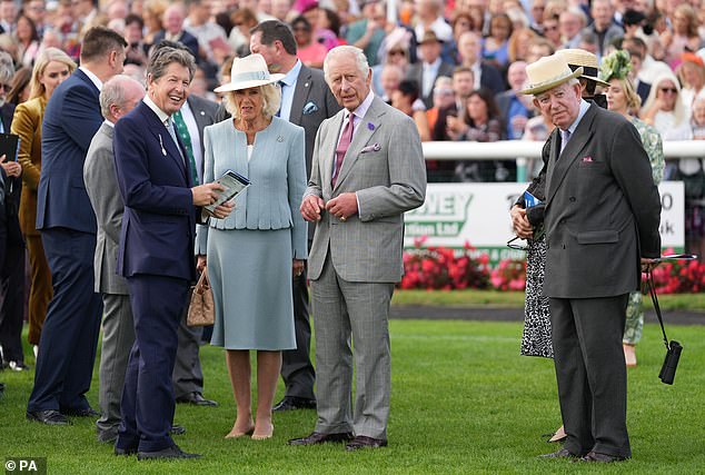 Charles chatted to his racing adviser John Warren (left) during the games