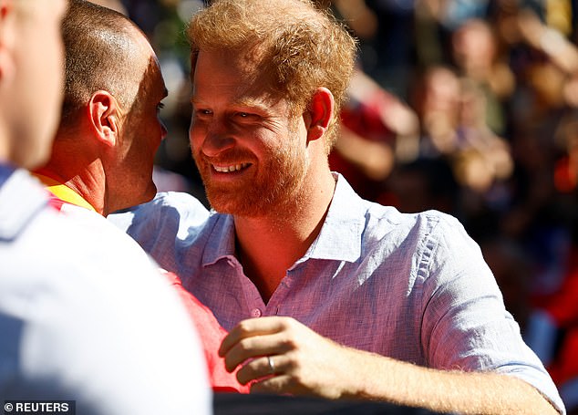 Harry hugs a competitor at the cycling medal ceremony