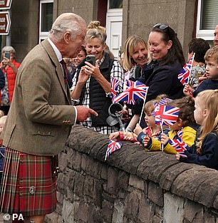 Meanwhile the royal also accepted poseys of flowers and spoke to school children waving Union flags