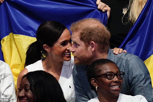 The couple were seen laughing as they cozied up to each other during the volleyball match earlier yesterday