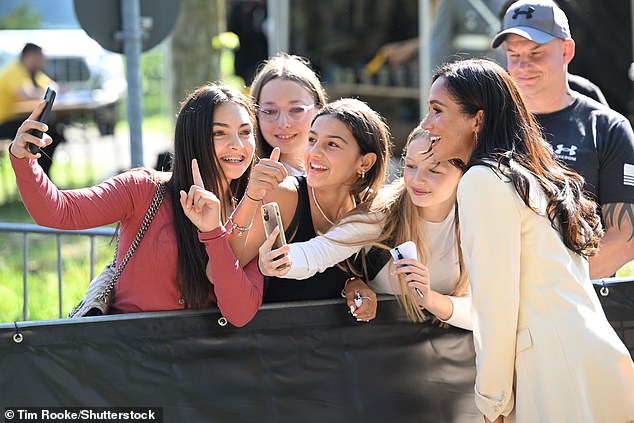 Meghan seemed more than happy to grant selfie requests from eager fans - including one group of women who urged the stylish Duchess to pose for their photo