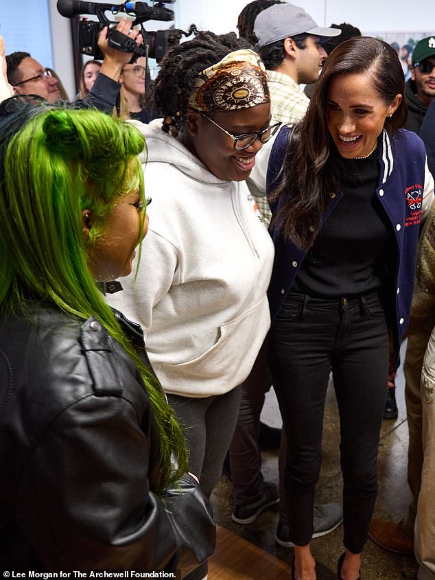 The Duchess sported black skinny jeans, a form-fitting black top, and a pair of heels - along with the letterman jacket that she received from a debate team at a school in the UK back in March 2020