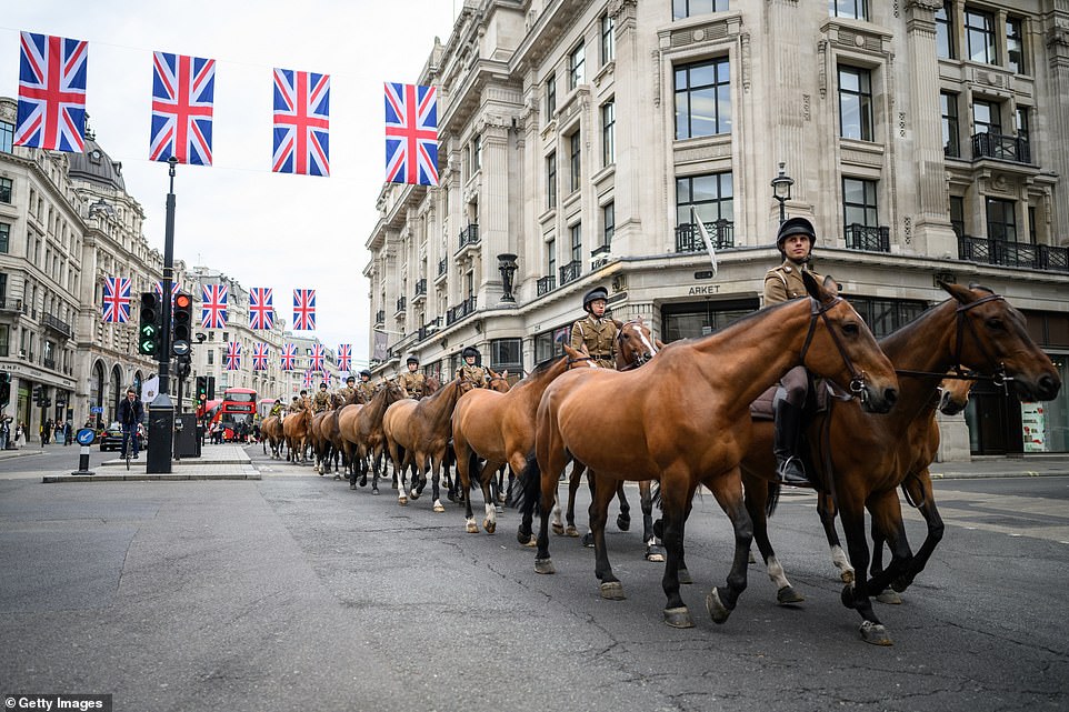 Union flags hang above as horses are walked along Regent Street in London today ahead of the Platinum Jubilee celebrations