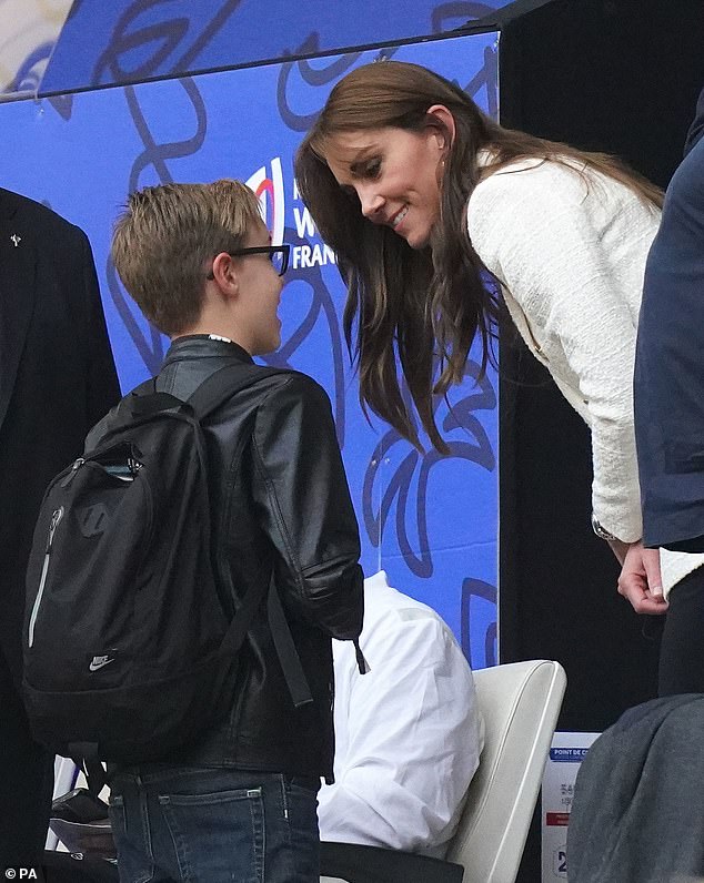 Princess of Wales meets a young fan in the stands at half-time