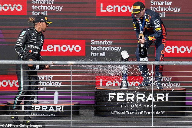 Mercedes' Hamilton  and Red Bull Racing's Dutch driver Max Verstappen celebrate on the podium just hours before the British driver was disqualified