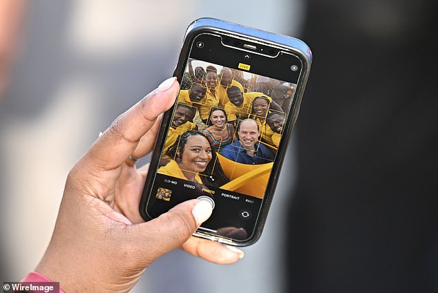 Locals take a selfie with Catherine and Prince William in Trench Town, the birthplace of reggae,  in Kingston, Jamaica, 2022