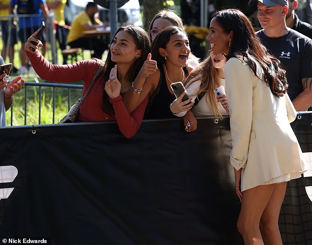 Meghan Markle got into the spirit of the Invictus Games today as she gleefully posed for selfies with fans outside the Merkur Spiel-Arena in Dusseldorf.