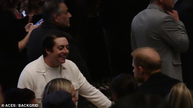 He looked to be greeted by excited fans while sitting down next to Meghan, ready for the show to begin