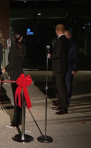 Meghan spotted Harry behind her talking to a dignitary - ushering him forward before the ribbon cutting