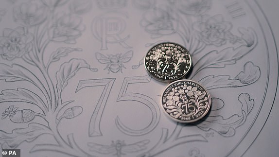 Undated handout photo issued by the Royal Mint of the new commemorative coins celebrating the 75th birthday of King Charles III, placed on top of a design. A new commemorative coin celebrating King Charles' 75th birthday and paying tribute to his passion for the natural world has been unveiled by the Royal Mint. To mark the occasion, Mint is looking for 75 people turning 75 years old this year, to gift them a special £5 coin, in honour of the King's birthday. Issue date: Monday November 6, 2023. PA Photo. See PA story MONEY Coins. Photo credit should read: Royal Mint/PA Wire NOTE TO EDITORS: This handout photo may only be used in for editorial reporting purposes for the contemporaneous illustration of events, things or the people in the image or facts mentioned in the caption. Reuse of the picture may require further permission from the copyright holder.