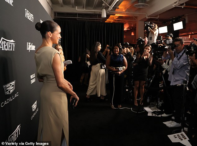 Meghan smiles for the assembled press in LA on Thursday evening