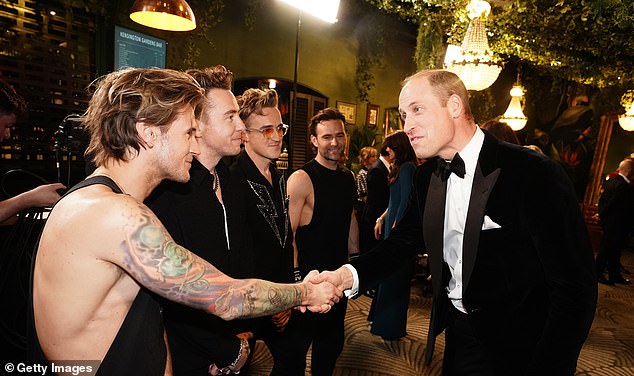 Prince William is snapped shaking hands with the members of the band McFly during the Royal Variety Performance at the Royal Albert Hall