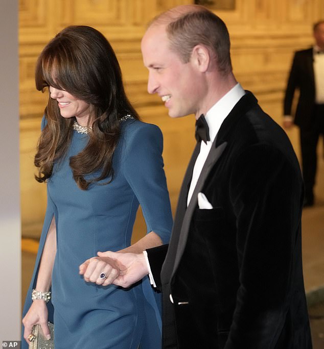 The Prince of Wales took his wife's hand as they walked along the red carpet into the Royal Albert Hall