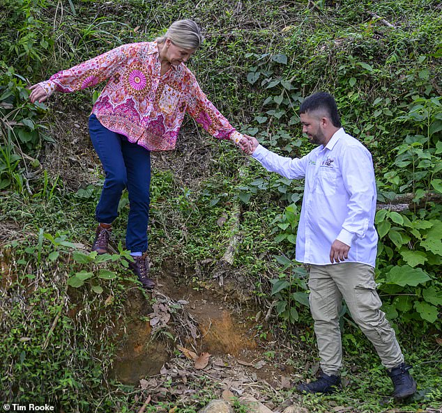 The royal was helped down the steep hills at the farm by a local worker