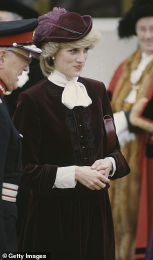 Princess Diana wears a wine-coloured hat to match her velvet suit by Jaeger and a John Boyd hat in November 1983