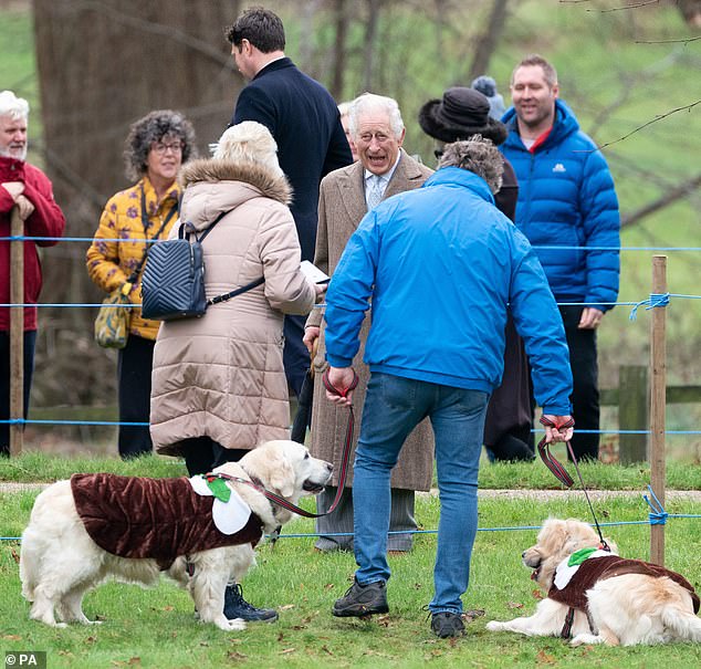 The King shares a joke with the owner of two dogs dressed as Christmas puddings as he left St Mary Magdalene Church on Christmas Eve