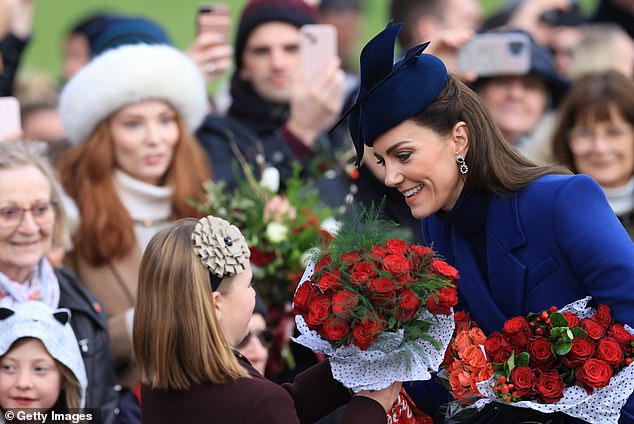 Catherine, Princess of Wales and Mia Tindall hands Mia Tindall flowers as they reet well-wishers after attending the Christmas Morning Service at Sandringham Church