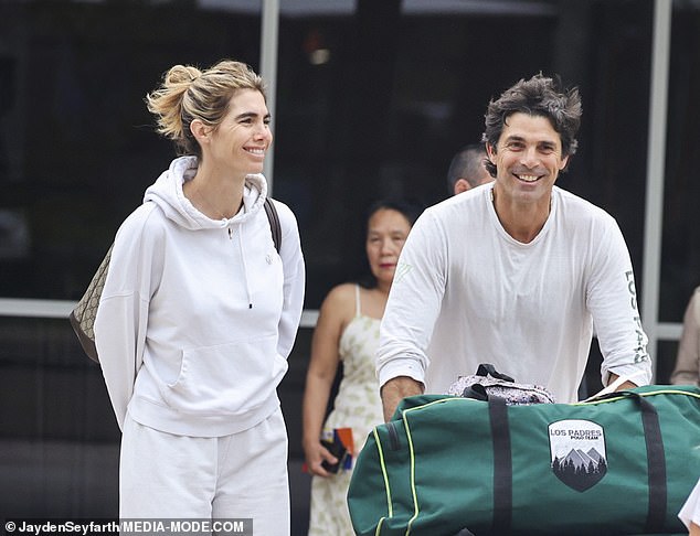 His jet black hair sported a windswept look and he appeared to be in good spirits as he made his way though the arrivals lounge with his stunning photographer wife, 43