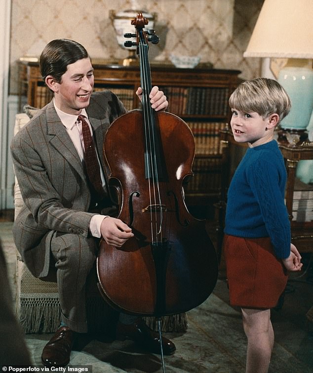 Prince Charles holds a cello as younger brother Prince Edward looks on during filming of the television documentary Royal Family in London in 1969