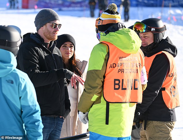 Harry speaks to staff at the Whistler ski-resort during a visit