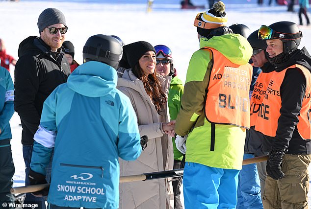 Meghan is seen shaking the hands of one of the training camp staff