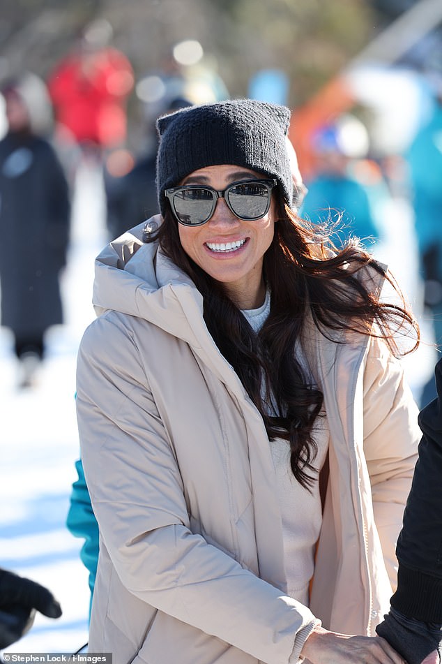 Meghan donned a pair of large black sunglasses as she smiled at photographers