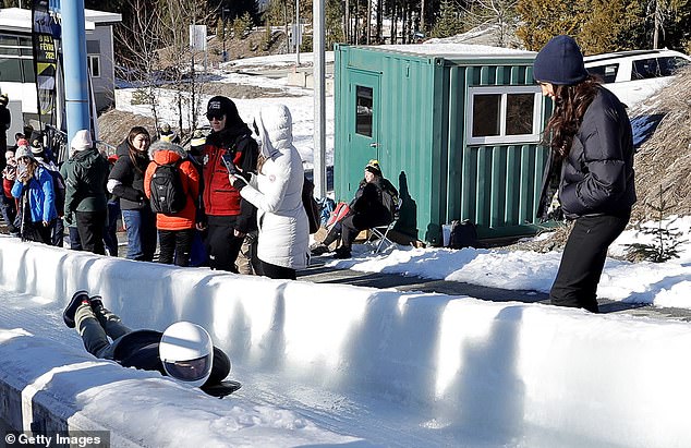 Meghan watching on as Harry tries his hand at skeleton bobsled