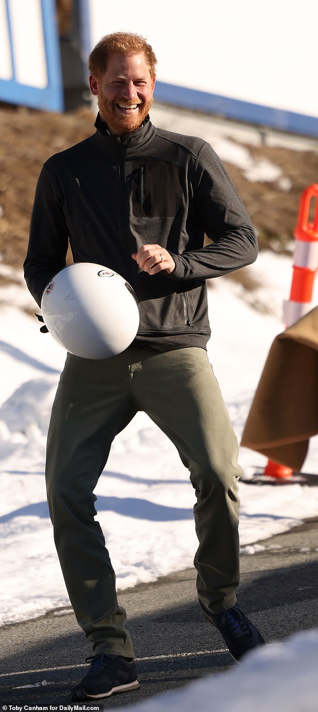 The Duke of Sussex laughed as he held his helmet and walked down the path yesterday