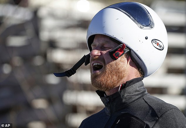 Prince Harry reacts after sliding down the track on a skeleton sled during an Invictus Games training camp, in Whistler, British Columbia