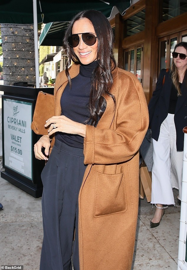 Looking typically stylish, the Duchess of Sussex , 42, rewore her tobacco-coloured cashmere Max Mara coat $6,250 (£4,935) for the occasion, teamed with $372 (£294) Givenchy pilot sunglasses