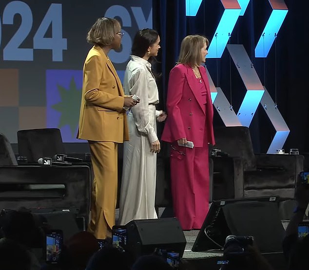 Meghan is seen standing next to Katie Couric (right) for the panel today