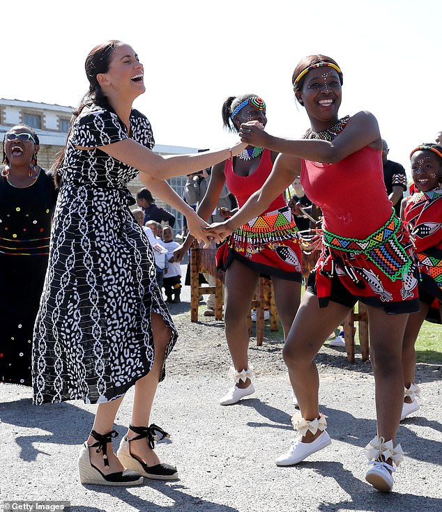 Harry and Meghan's ten-day tour with their son Archie began in Cape Town, South Africa. Above: Meghan dancing with locals in Nyanga township, South Africa