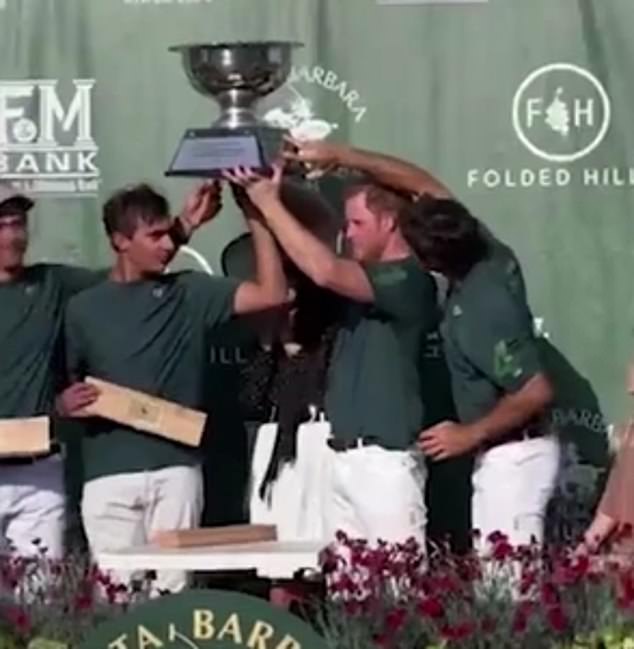 Stuck in the middle: Meghan Markle was on hand to present Prince Harry and his team with a trophy after they won an event at the Santa Barbara Polo & Racquet Club. But the moment had not been rehearsed and Meghan ended up being squashed between Harry and one of his teenage teammates as they struggled to lift the heavy cup over her head